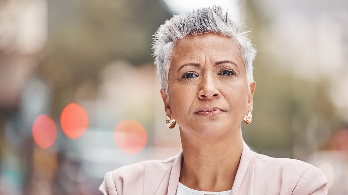 An attractive mature woman with short silver hair sure of herself and her choices